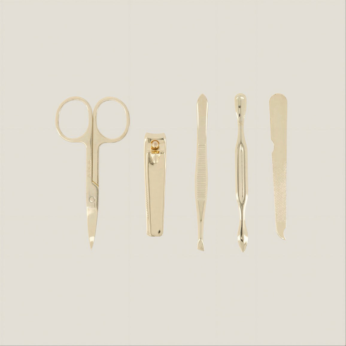 Set of gold grooming tools including scissors, clippers, and tweezers