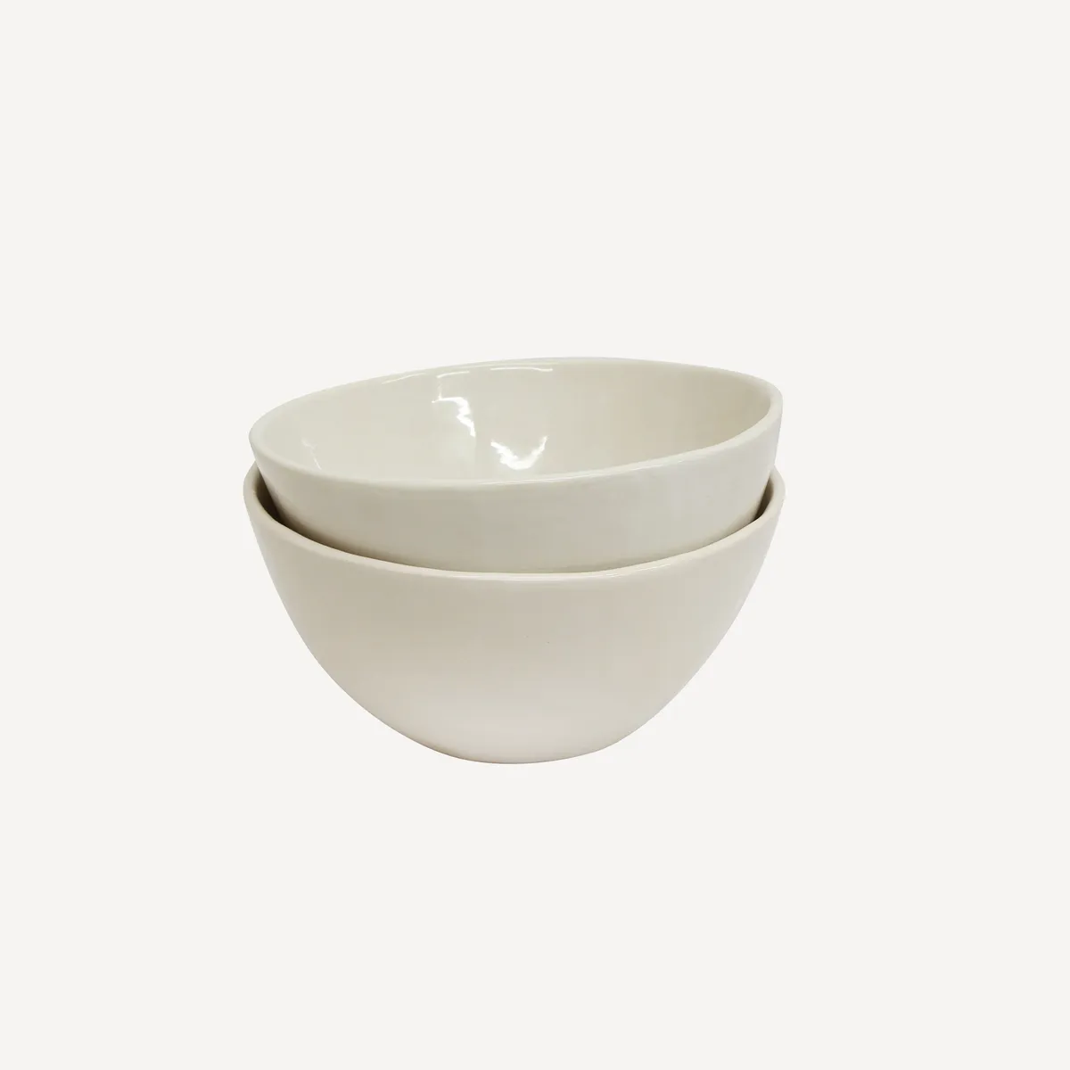 Three white ceramic bowls stacked on a white background