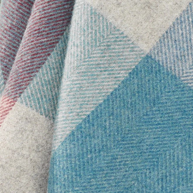 Close-up of a wool throw with geometric pattern in blue, gray, and red.