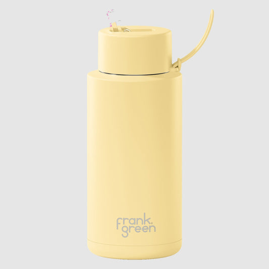 A yellow ceramic reusable water bottle with a straw lid, branded with 'frank green'.