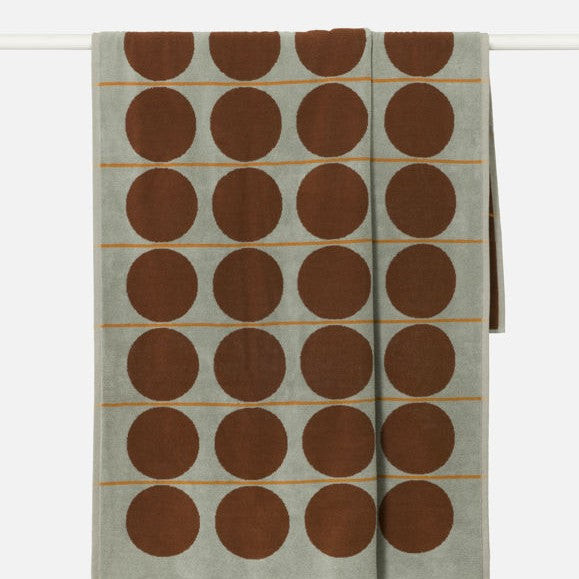Textile with brown circular patterns on a light green background