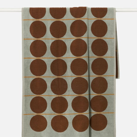 Textile with brown circular patterns on a light green background
