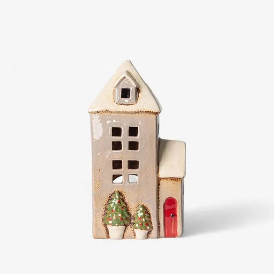 Decorative ceramic house with a red door and green trees 