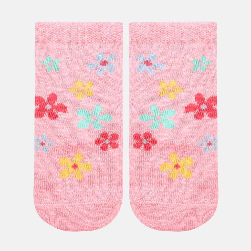 A pair of pink baby ankle socks with a jacquard pattern featuring multicolored daisies.