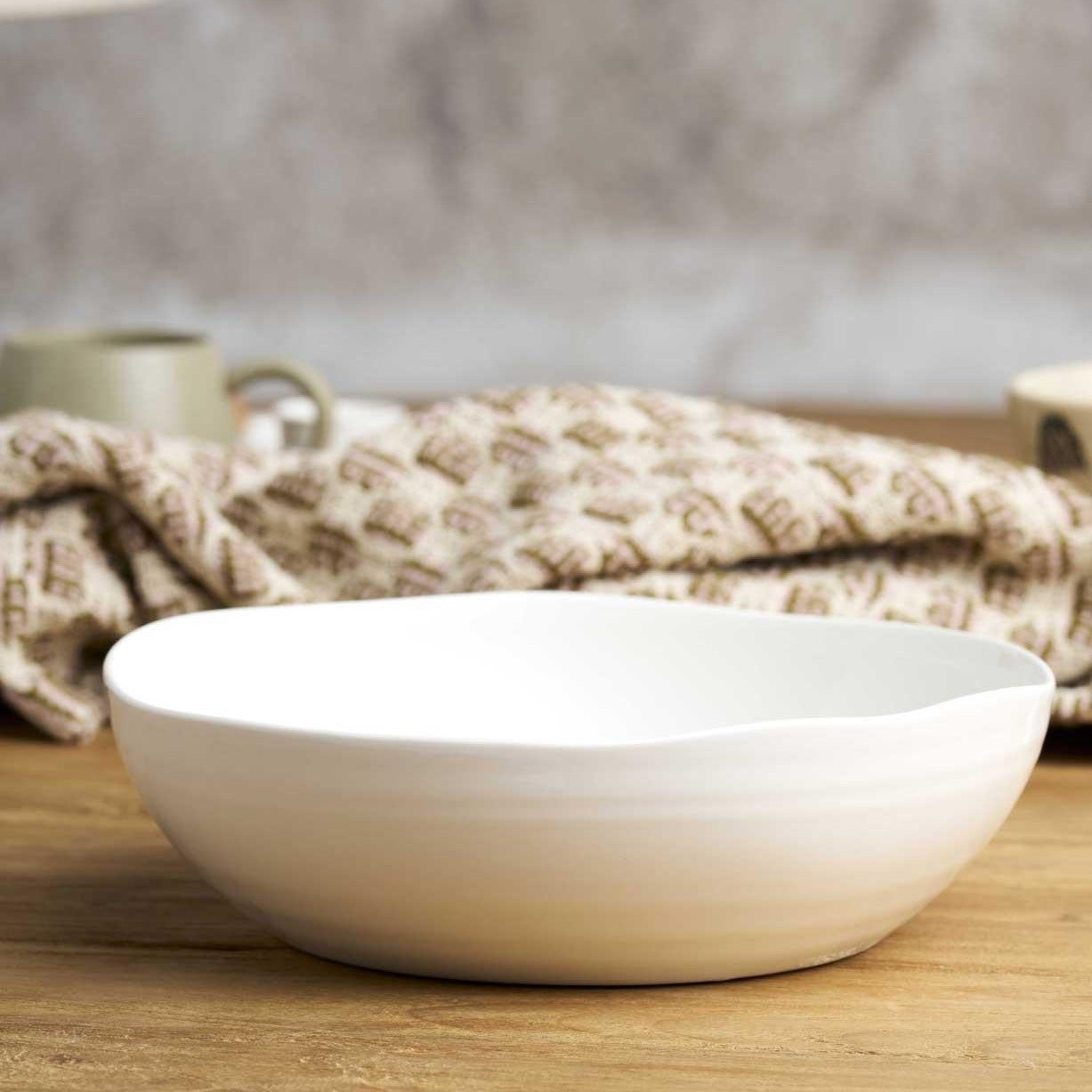 A white ceramic serving bowl with an undulating rim