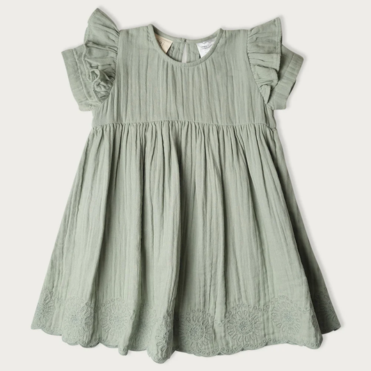 A sage green cotton gauze dress for toddlers, featuring ruffled cap sleeves, a gathered waist, and embroidered floral lace trim at the hem
