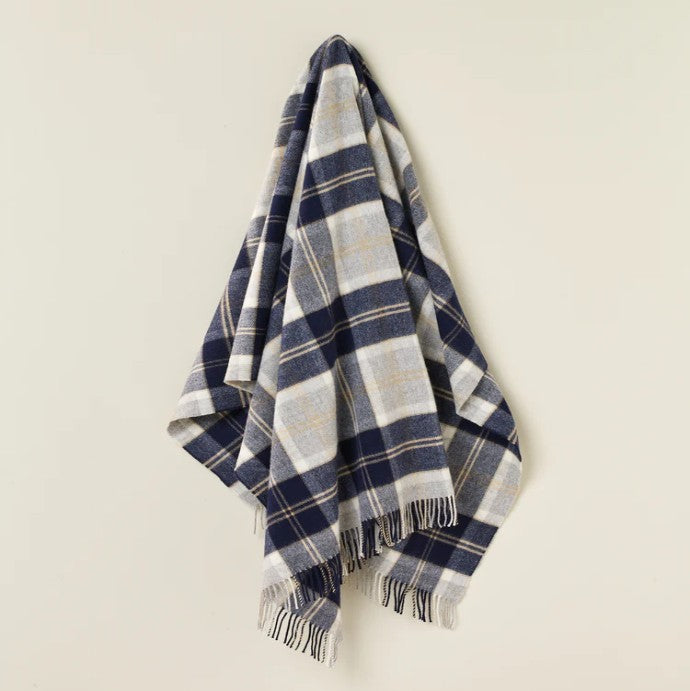 Plaid blanket with blue and white pattern on a beige background