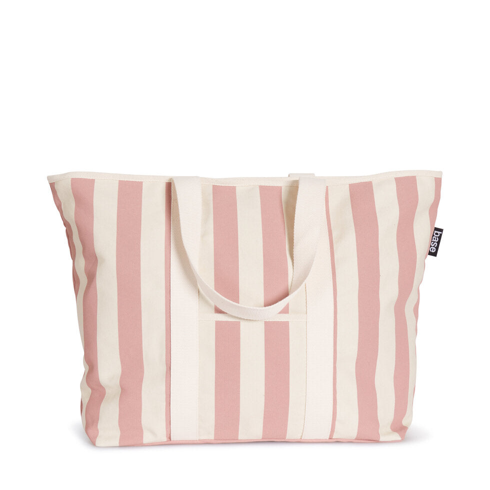 A canvas tote bag with pink and white stripes, featuring a front storage pocket and a zip top closure.