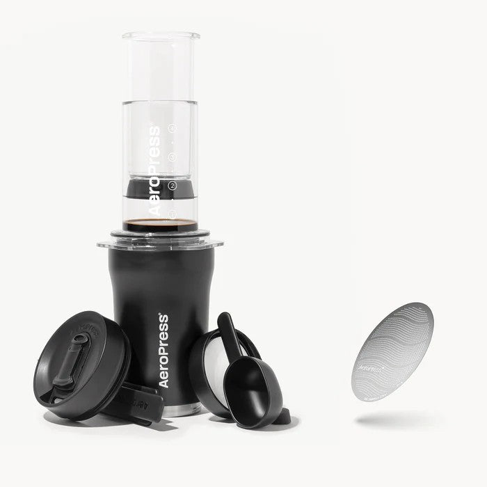 Aeropress coffee maker with components on a white background