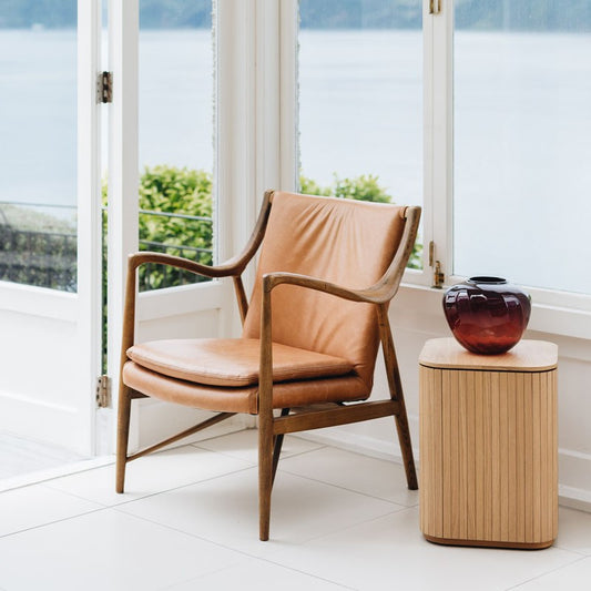 A cognac leather armchair with a solid wooden frame, 