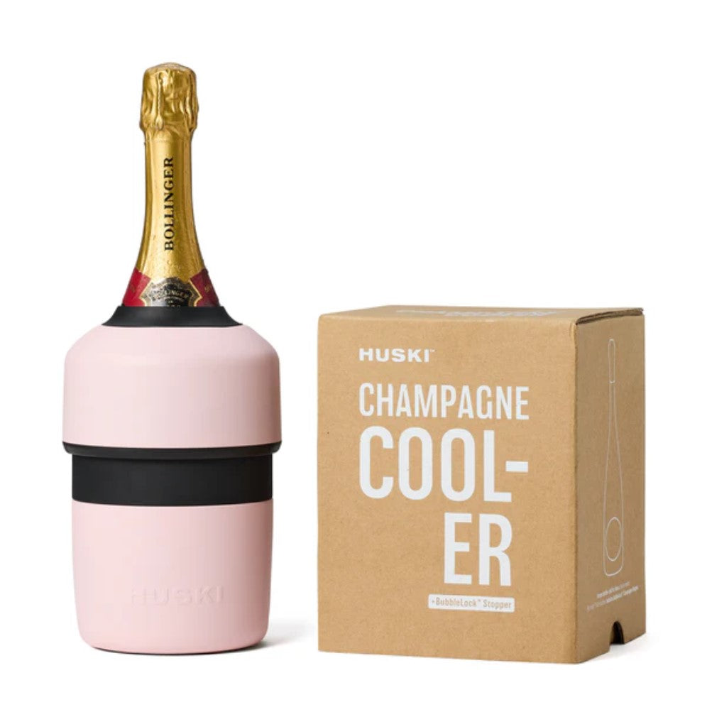A pink Huski Champagne Cooler fitted with a bottle, displayed alongside its packaging box.