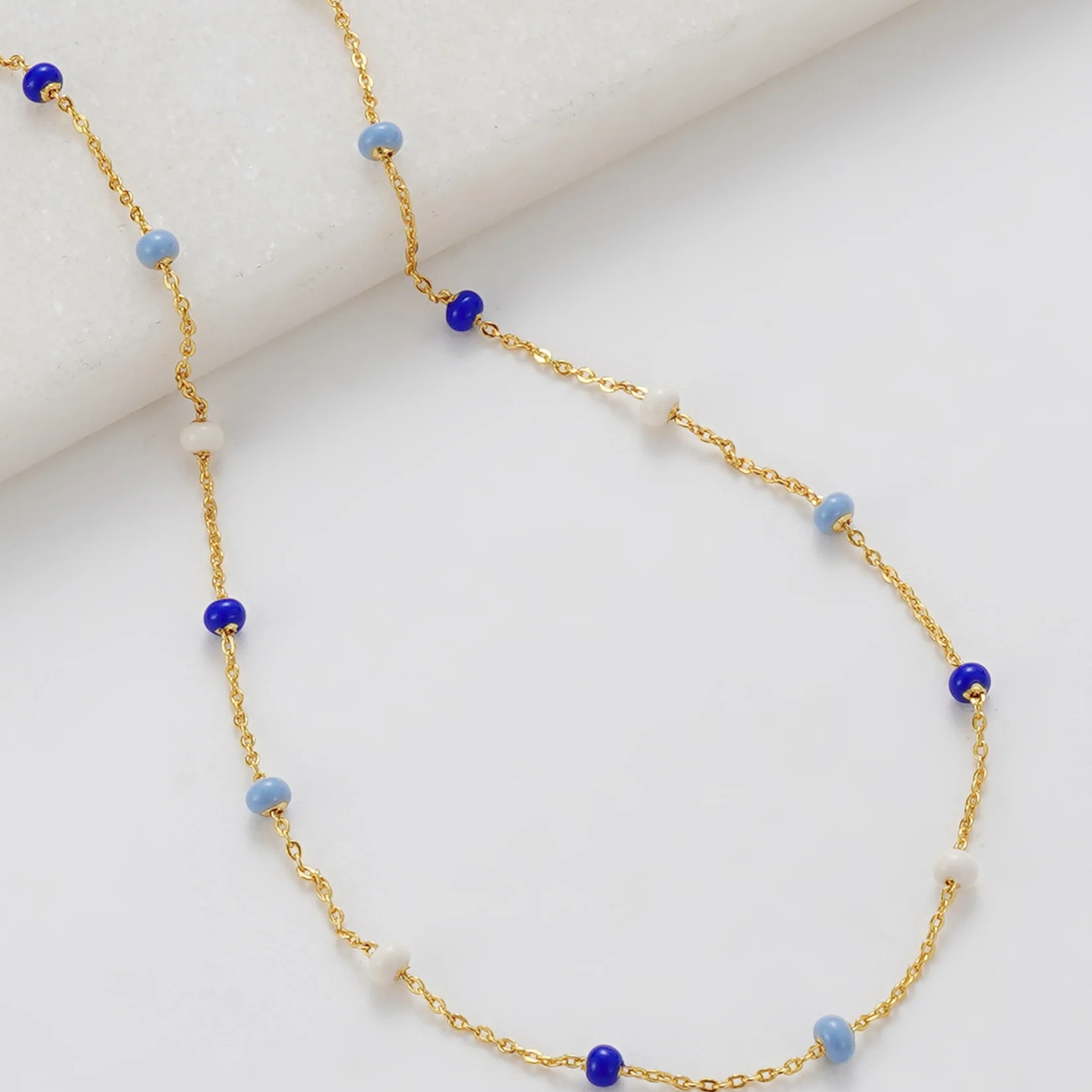 Gold necklace with blue and white beads