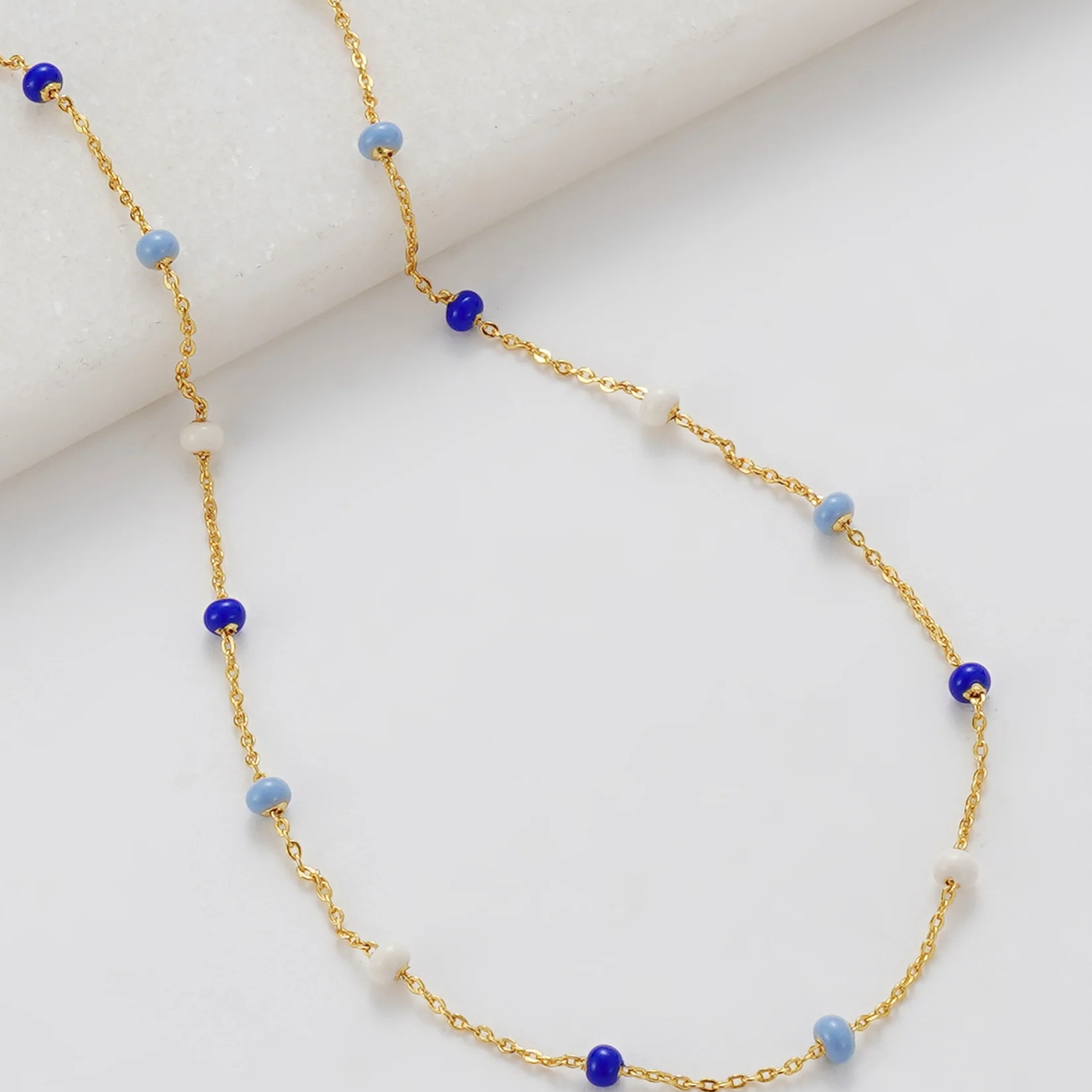 Gold necklace with blue and white beads