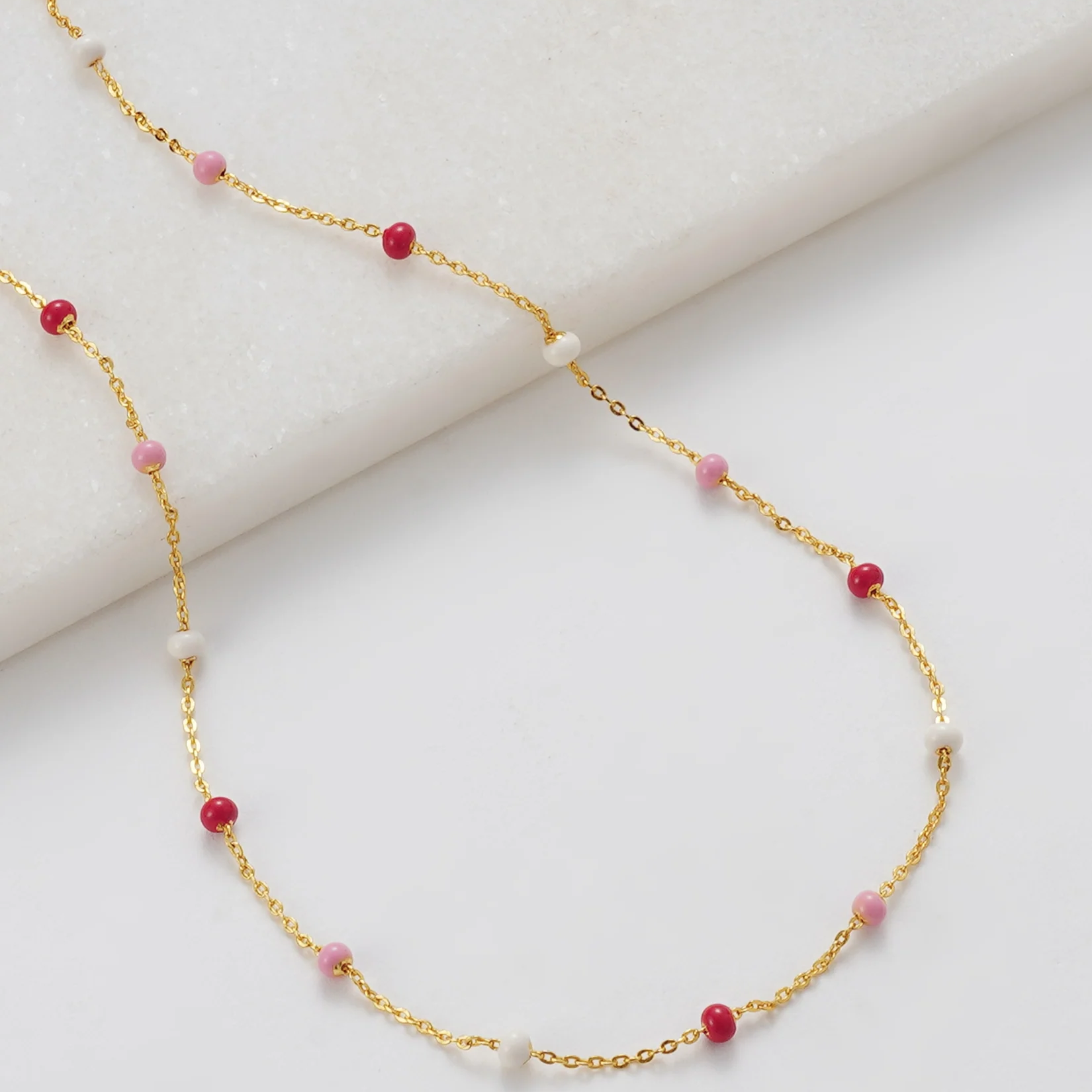 Gold necklace with red and pink beads