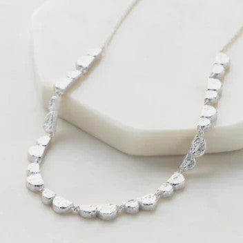 A silver-colored necklace with a series of round charms linked together