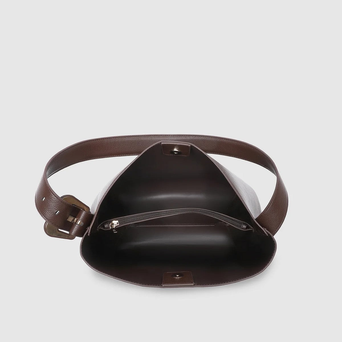 Brown vegan leather bag with a strap on a light gray background