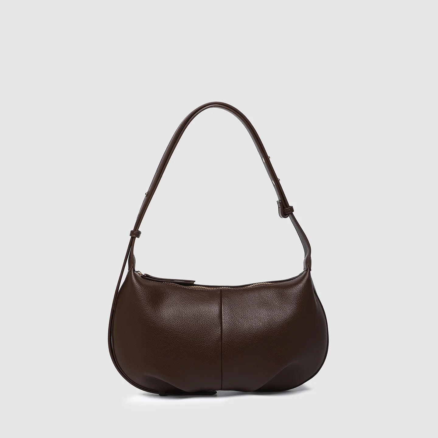 Brown vegan leather handbag on a light gray background