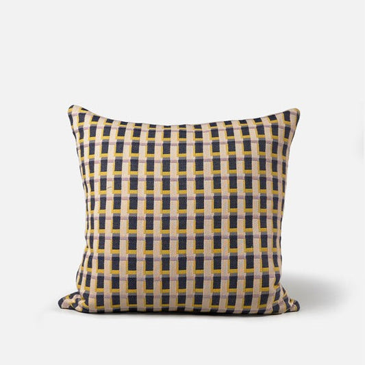 A square-shaped cushion with a geometric grid pattern in yellow, black, and other colors, featuring a feather inner.