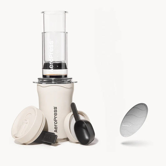 Aeropress coffee maker with components on a white background