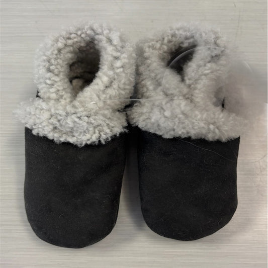 A pair of dark grey lambskin booties with elastic closure, designed for babies.