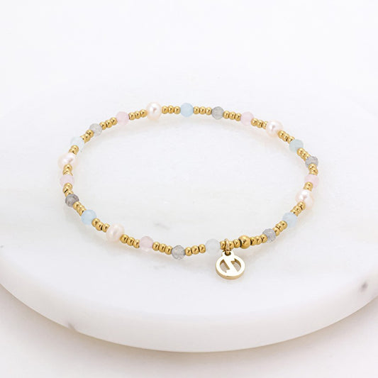 Bracelet with gold and gray beads on a white background