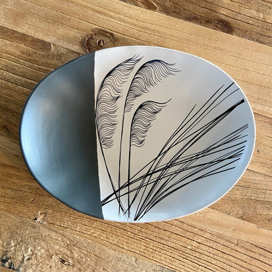 A 24cm round porcelain bowl with a black line design on a white background, displayed on a wooden surface.

