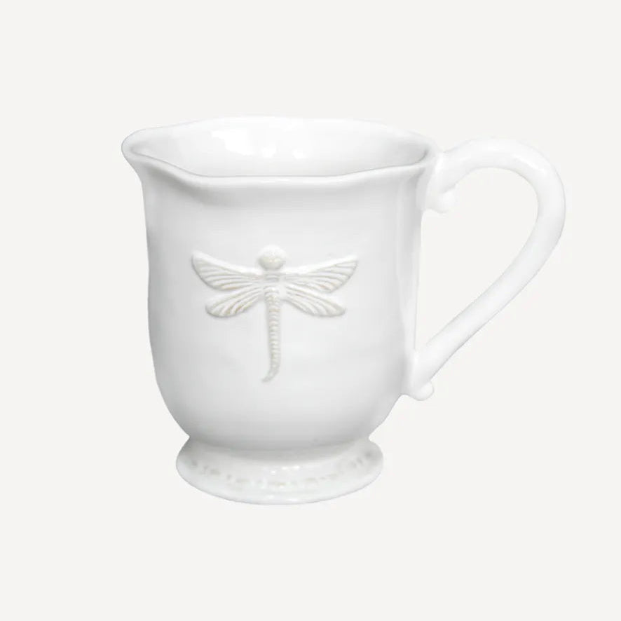 White ceramic mug with dragonfly design on a white background