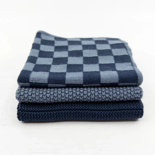 Stack of folded dish cloths with checkered and solid patterns