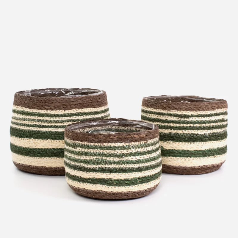 Three woven cylindrical baskets with horizontal stripes in brown, dark green, and cream, arranged on a light gray studio background.