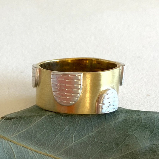 A sterling silver and yellow brass ring with 'mounds' on the top