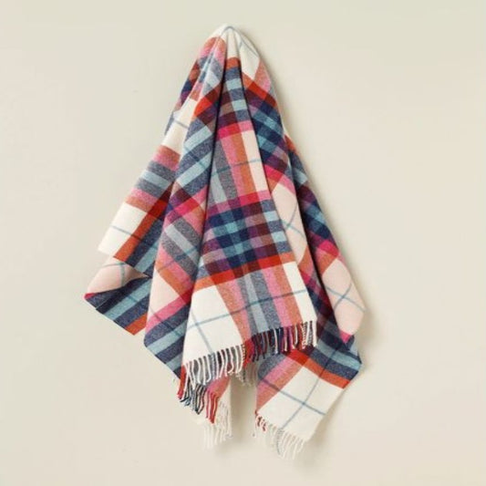 Plaid wool blanket with red, blue, and white colors on a beige background