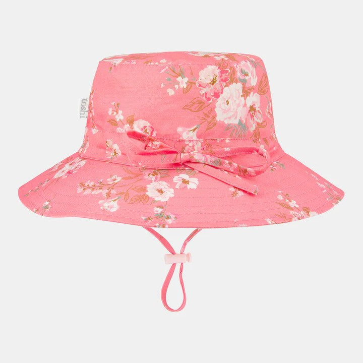 A pink floral sun hat with a wide brim and a head tie for adjustable sizing.
