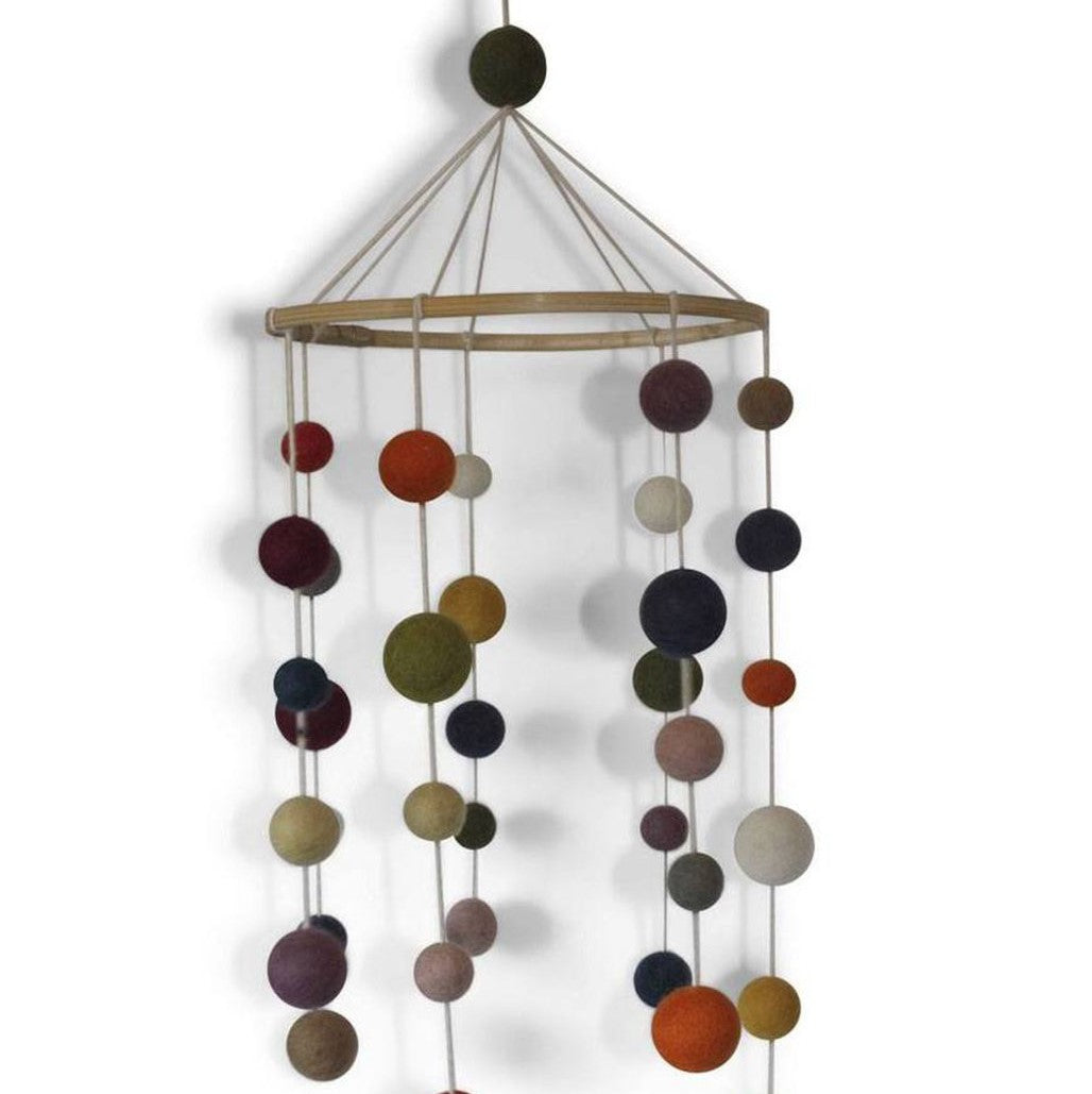 A handcrafted felt mobile with various colored circular shapes connected by strings to a wooden ring at the top.