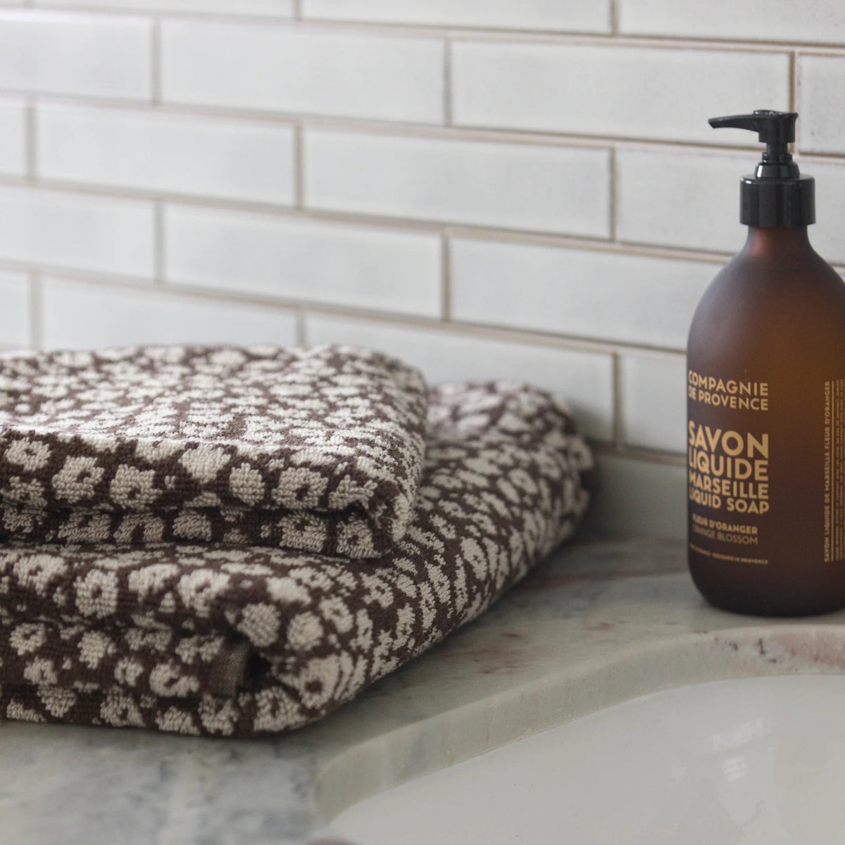 A brown and cream patterned folded hand towel 