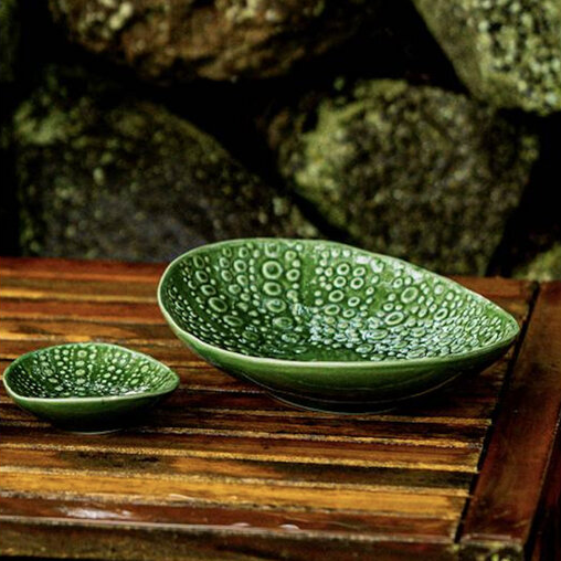Two green ceramic bowls with a textured pattern in the form of a Kina 