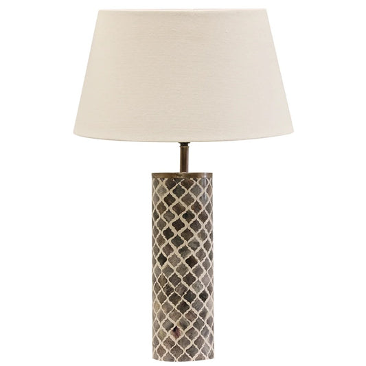A table lamp with a grey and white geometric patterned base and an ivory tapered drum lampshade.