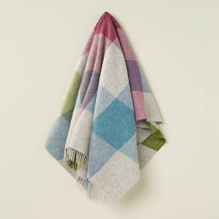 Colorful diamond patterned wool throw blanket on a white background