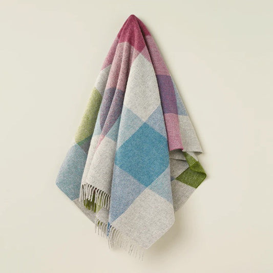 Colorful diamond patterned wool throw blanket on a white background