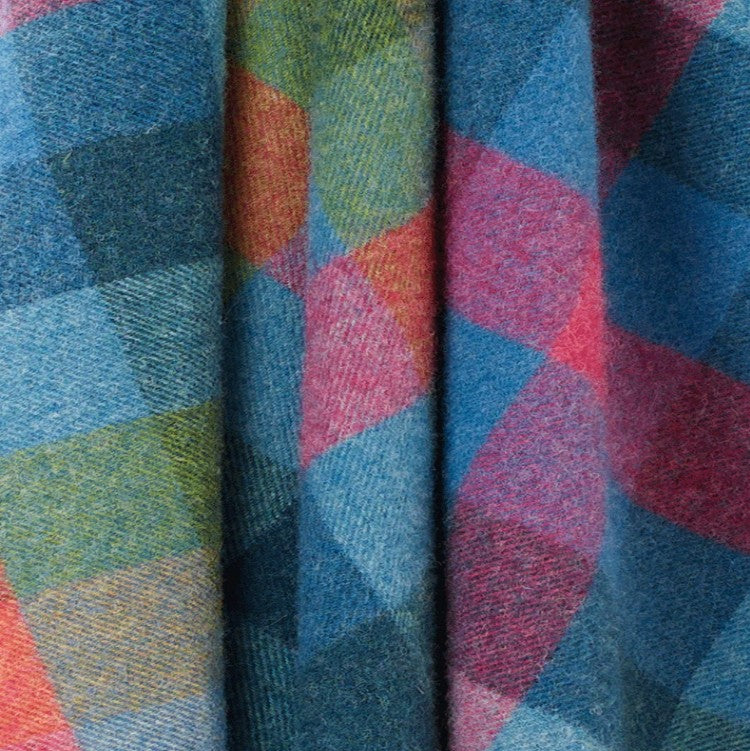 Close-up of wool throw with geometric pattern in blue, green, pink, and red.