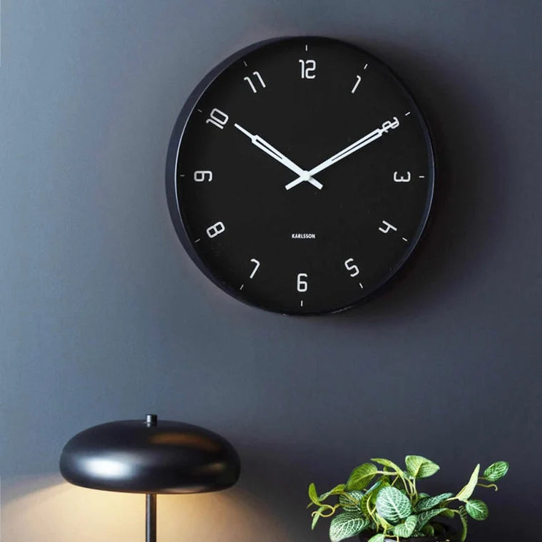 Black wall clock on a dark modern setting 