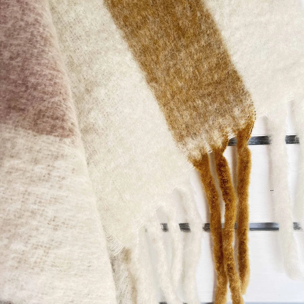 Close-up of a textured fabric with a gradient from beige to brown.