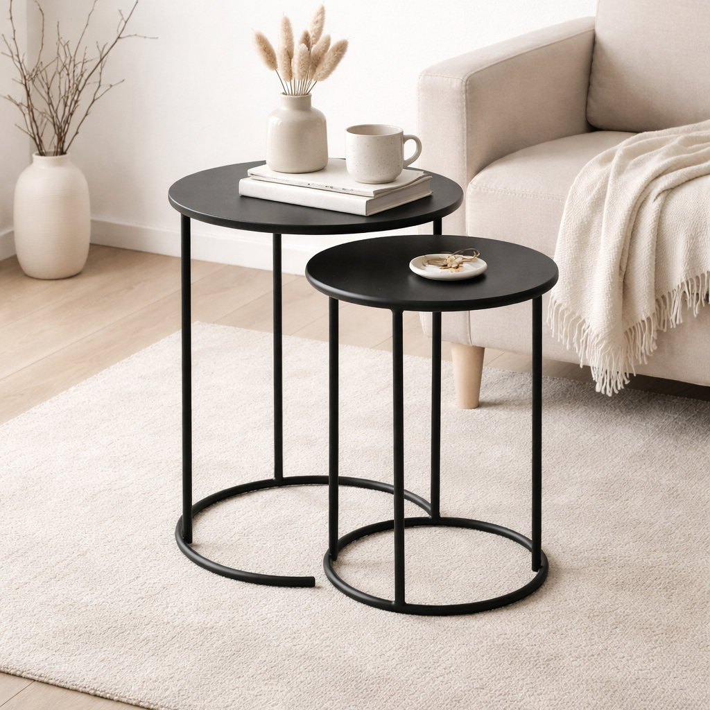 Two black side tables in a living room setting with decor items.