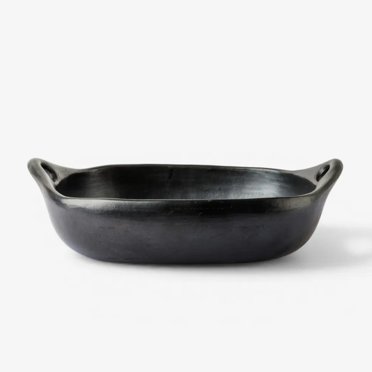 Black clay oven dish with handles on a white background