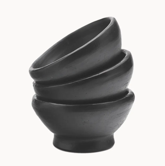 Stack of three black clay bowls on a white background