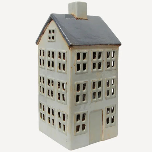 A large white and blue ceramic tea light holder designed to resemble a house with multiple windows and a roof.