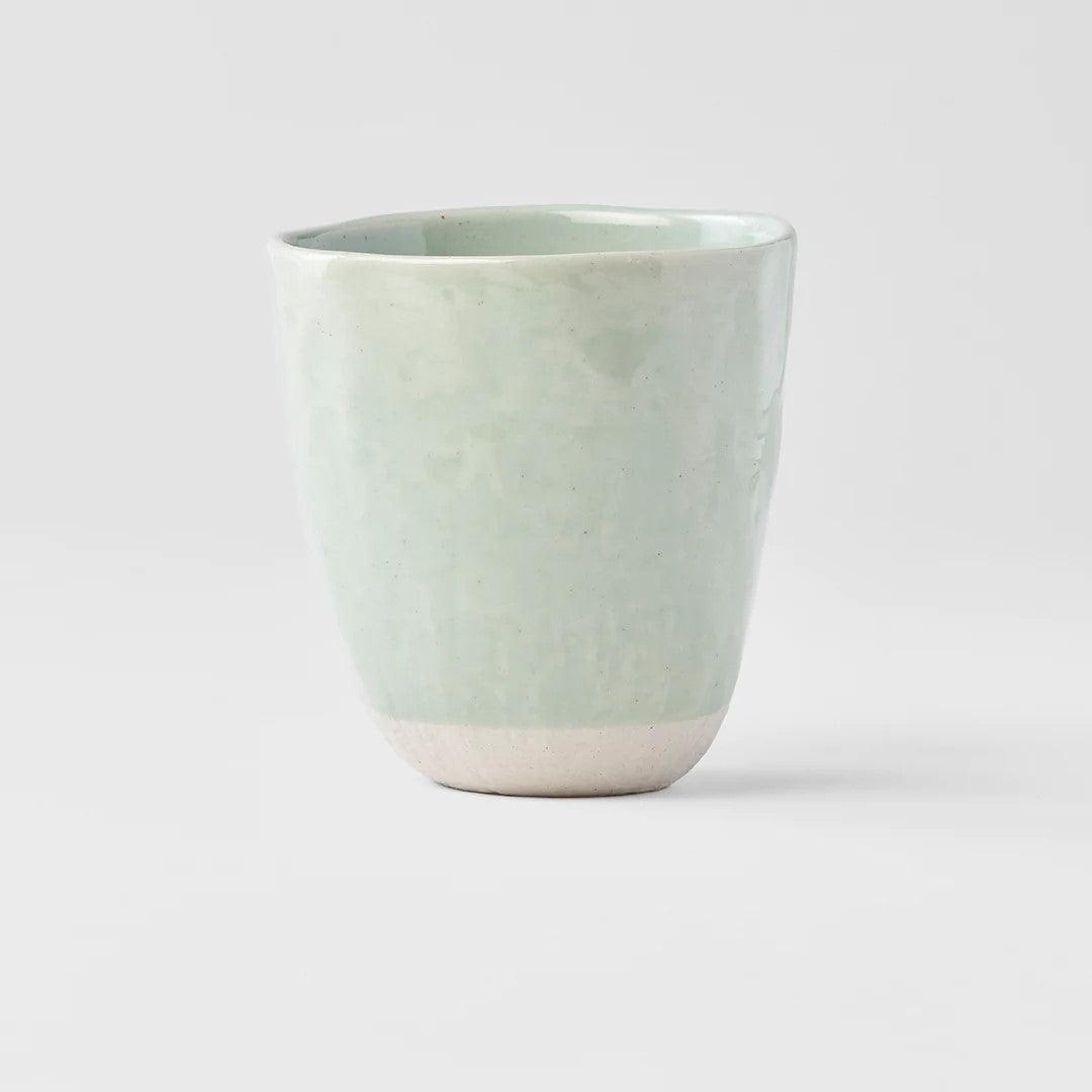A light teal lopsided ceramic mug with a matte finish, showing a subtle texture variation.