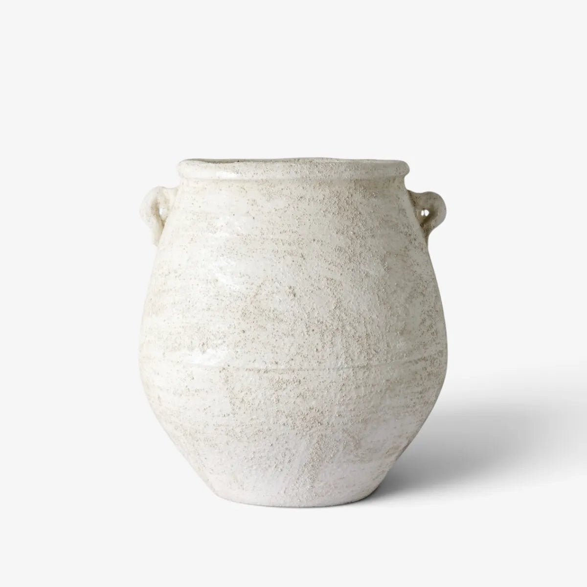 A rustic, handcrafted ceramic vase with a textured off-white glaze and two small loop handles, set against a clean white background.