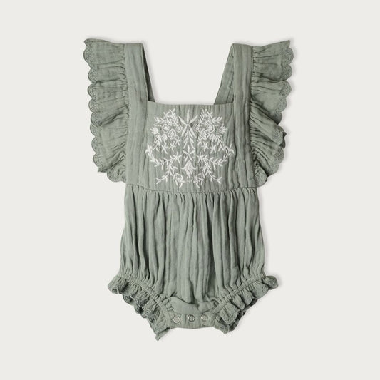 A green bodysuit with embroidered detailing on the front and ruffles, featuring an elastic waistband and adjustable tie up back.