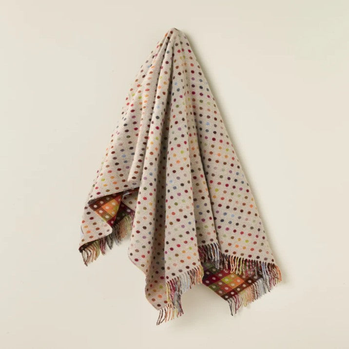 Polka dot wool throw draped over a white surface