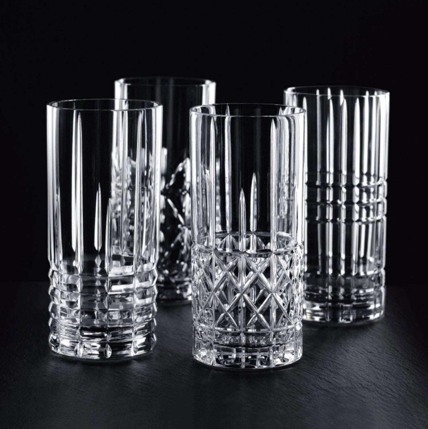 A set of four clear highball crystal  glasses with a geometric pattern,
